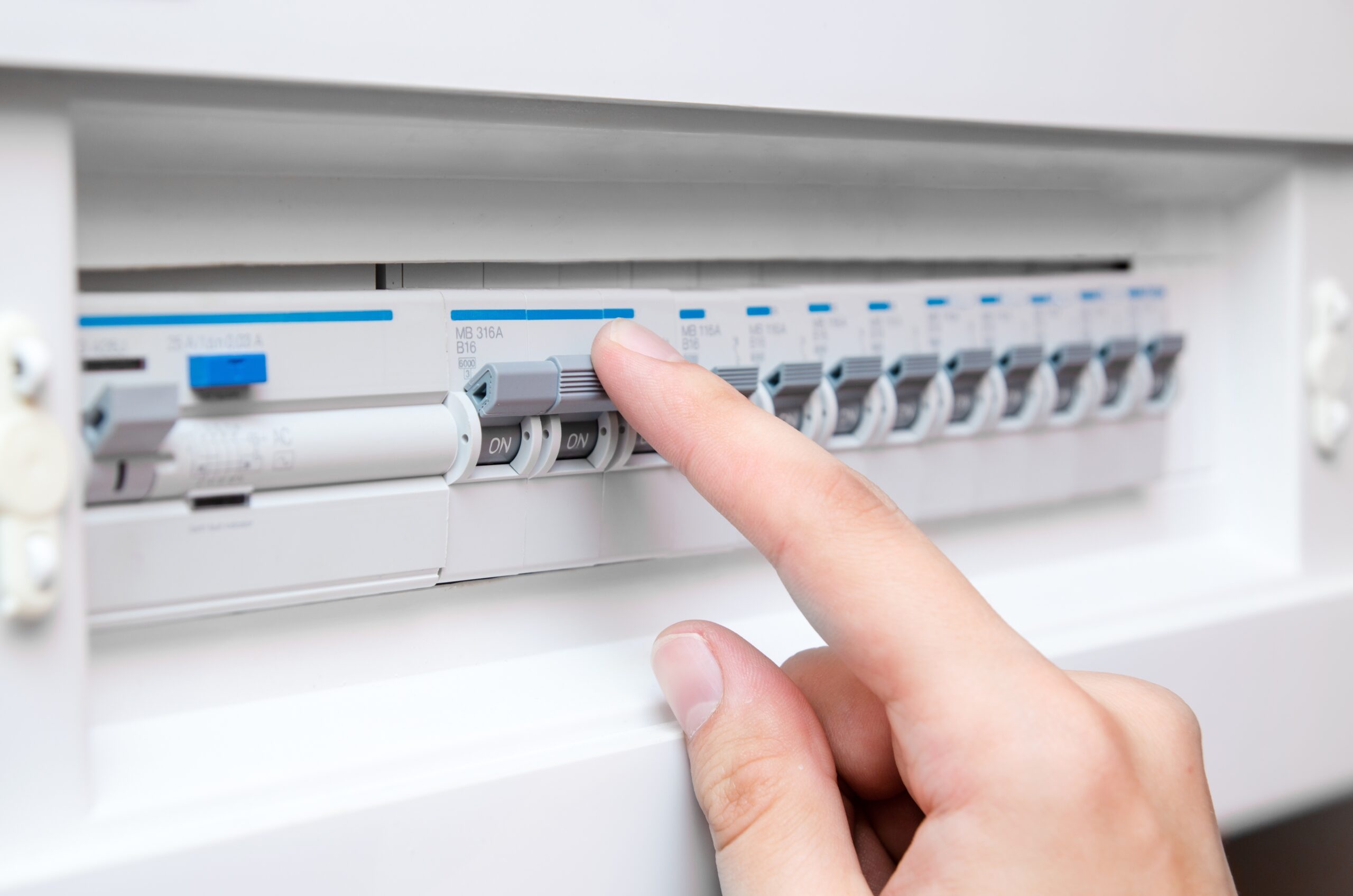 Hand schaltet Sicherung im Sicherungskasten aus
